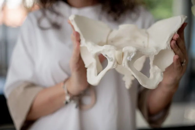 Silvia holding a rubber pelvic bone structure, for demonstration in her antenatal class.