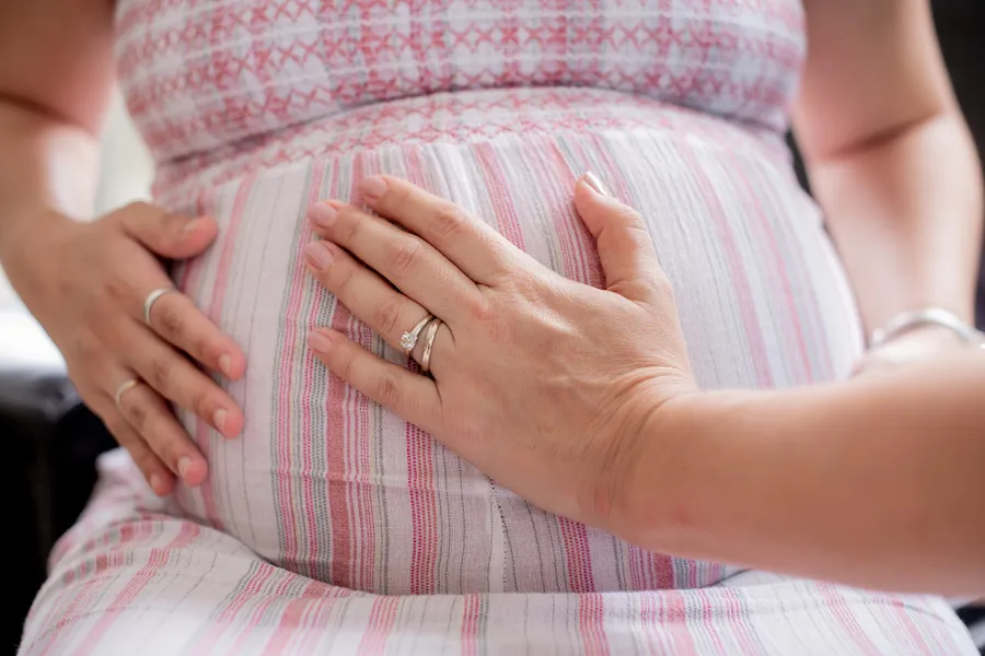 Silvia feeling the baby movements in a pregnant woman's belle with her palm.