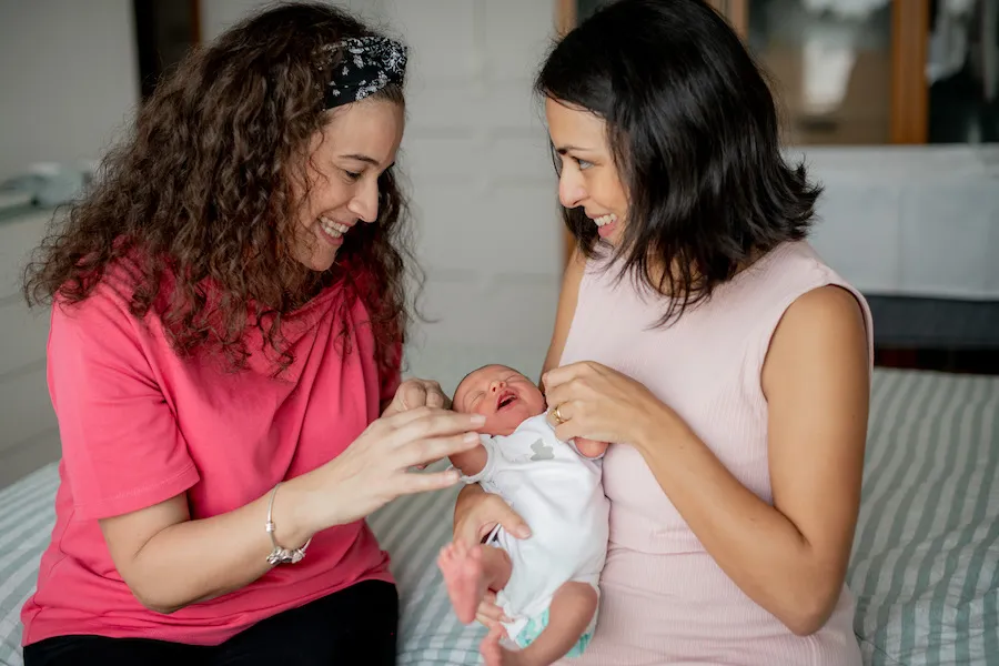 A lactating mother carrying her baby, and smiling with Silvia.