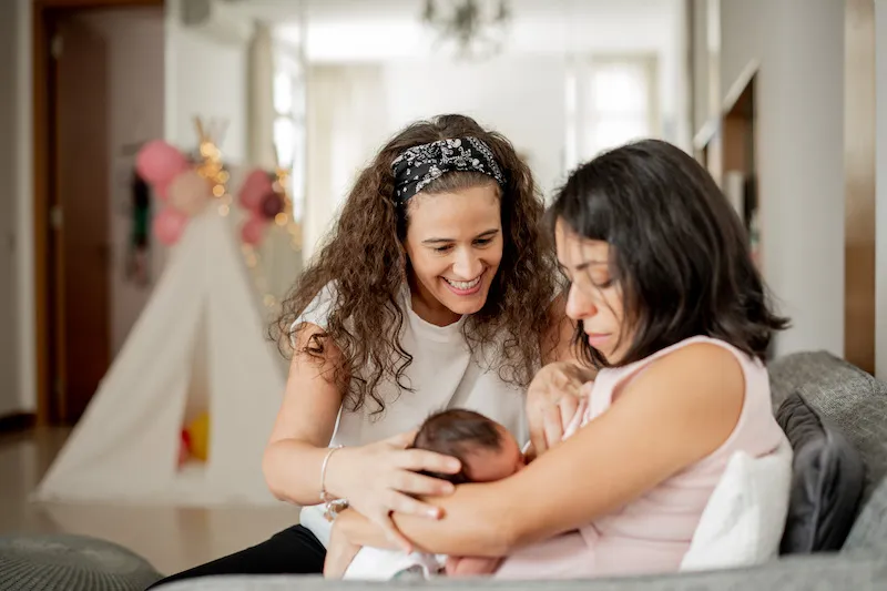 A lactating mother breastfeeding her baby, as Silvia properly supports the baby's head encouraging him to feed more.