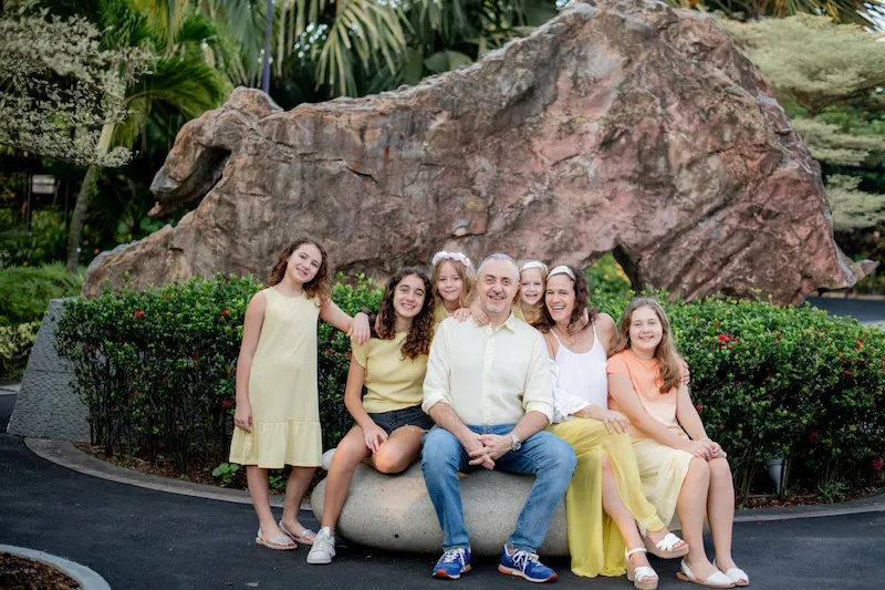 Silvia, her husband, and her kids all smiling in a group photo.