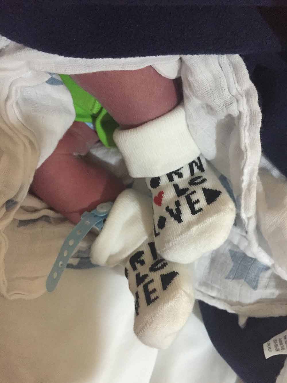 A baby's beautiful feet, with cute socks worn on them.